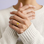 Woman wearing oval shaped 3 stone engagement ring with soft sparkle.