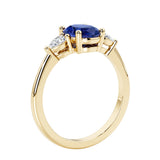 3 stone wedding ring with oval center gemstone and pear shape diamond side stones.