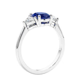 3 stone oval ring with blue gemstone and diamonds in sleek white gold.