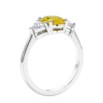 3 stone oval ring with yellow gemstone and diamonds in sleek white gold.