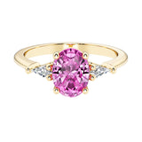 Oval cut three stone pink sapphire engagement ring with diamonds set yellow gold.