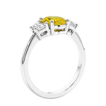 Engagement ring with oval shaped yellow gemstone and diamonds in a 3 stone design.