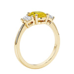 3 stone wedding ring with oval center yellow gemstone and diamond side stones.