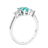 3 stone diamond engagement ring with pear shaped center in white gold featuring Green Gemstone.