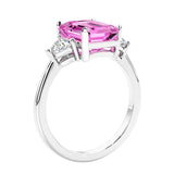 3 stone emerald cut diamond ring in modern gold setting with pink gemstone center.