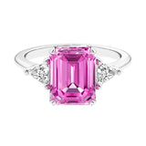 Three stone emerald cut engagement ring for timeless elegance featuring pink gemstone and diamonds.