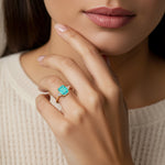 Woman wearing emerald cut three stone engagement ring with bold lines.