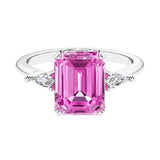 Three stone emerald cut engagement ring for timeless elegance featuring pink gemstone and diamonds.