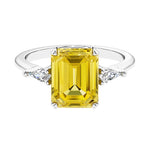 Three stone emerald cut engagement ring for timeless elegance featuring pink gemstone and diamonds.