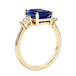 Emerald cut 3 diamond ring representing past, present, and future featuring blue gemstone center.