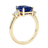 Emerald cut 3 diamond ring representing past, present, and future featuring blue gemstone center.
