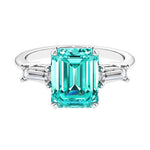 Three stone emerald cut engagement ring for timeless elegance featuring green gemstone and diamonds.