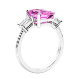 3 stone emerald cut diamond ring in modern gold setting with pink gemstone center.