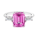 Three stone emerald cut engagement ring for timeless elegance featuring pink gemstone and diamonds.