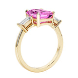 Emerald cut 3 diamond ring representing past, present, and future featuring pink gemstone center.