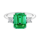 Three stone emerald cut engagement ring for timeless elegance featuring green gemstone and diamonds.