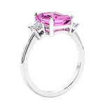 3 stone emerald cut diamond ring in modern gold setting with pink gemstone center.