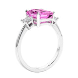 3 stone emerald cut diamond ring in modern gold setting with pink gemstone center.