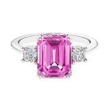 Three stone emerald cut engagement ring for timeless elegance featuring pink gemstone and diamonds.