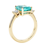 Emerald cut 3 diamond ring representing past, present, and future featuring green gemstone center.