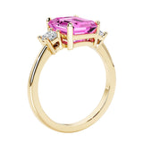 Emerald cut 3 diamond ring representing past, present, and future featuring pink gemstone center.