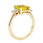 Emerald cut 3 diamond ring representing past, present, and future featuring yellow gemstone center.