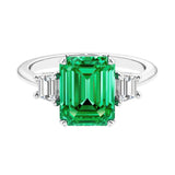 Three stone emerald cut engagement ring for timeless elegance featuring green gemstone and diamonds.