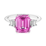 Three stone emerald cut engagement ring for timeless elegance featuring pink gemstone and diamonds.