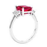3 stone emerald cut diamond ring in modern gold setting with red gemstone center.