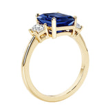 Emerald cut 3 diamond ring representing past, present, and future featuring blue gemstone center.