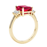 Emerald cut 3 diamond ring representing past, present, and future featuring red gemstone center.