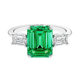 Three stone emerald cut engagement ring for timeless elegance featuring green gemstone and diamonds.