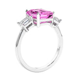 3 stone emerald cut diamond ring in modern gold setting with pink gemstone center.