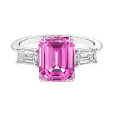 Three stone emerald cut engagement ring for timeless elegance featuring pink gemstone and diamonds.