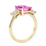 Emerald cut 3 diamond ring representing past, present, and future featuring pink gemstone center.