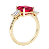 Emerald cut 3 diamond ring representing past, present, and future featuring red gemstone center.