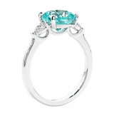 Cushion cut diamond ring as a unique engagement ring featuring three stone design with paraiba tourmaline and diamonds.