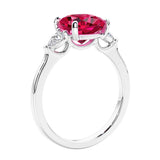 Cushion cut diamond ring as a unique engagement ring featuring three stone design with red ruby and diamonds.