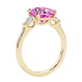 Three stone cushion diamond ring in yellow gold setting with pink sapphire and diamonds.
