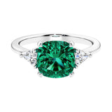Cushion shaped engagement ring with brilliant diamonds and green emerald.