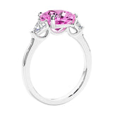 Cushion cut diamond ring as a unique engagement ring featuring three stone design with pink sapphire and diamonds.