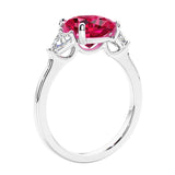 Cushion cut diamond ring as a unique engagement ring featuring three stone design with ruby and diamonds.