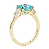 Three stone cushion diamond ring in yellow gold setting with paraiba tourmaline and diamonds.