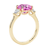 Three stone cushion diamond ring in yellow gold setting with pink sapphire and diamonds.