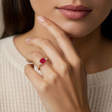 Woman wearing a cushion cut 3 stone ring with romantic styling featuring ruby and diamonds.