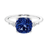 Cushion shaped engagement ring with brilliant diamonds and blue gemstone.