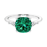 Cushion shaped engagement ring with brilliant diamonds and green gemstone.