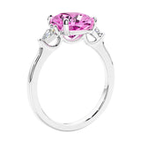 Cushion cut diamond ring as a unique engagement ring featuring three stone design with pink gemstone and diamonds.