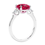 Cushion cut diamond ring as a unique engagement ring featuring three stone design with red gemstone and diamonds.