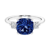 Cushion shaped engagement ring with brilliant diamonds and blue gemstone.